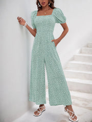 Light green floral print smocked bodice jumpsuit with puff sleeves and wide legs.