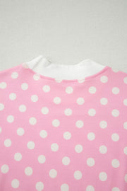 Pink polka dot top with white ribbed mock neck detail