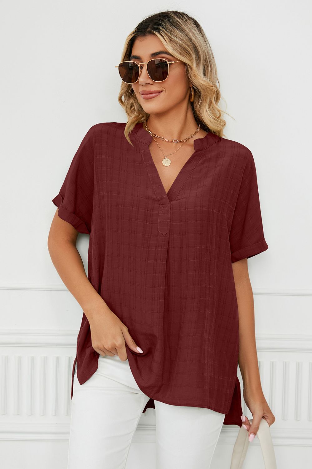 Burgundy linen blouse with V-neck, short sleeves, and gathered back detail.