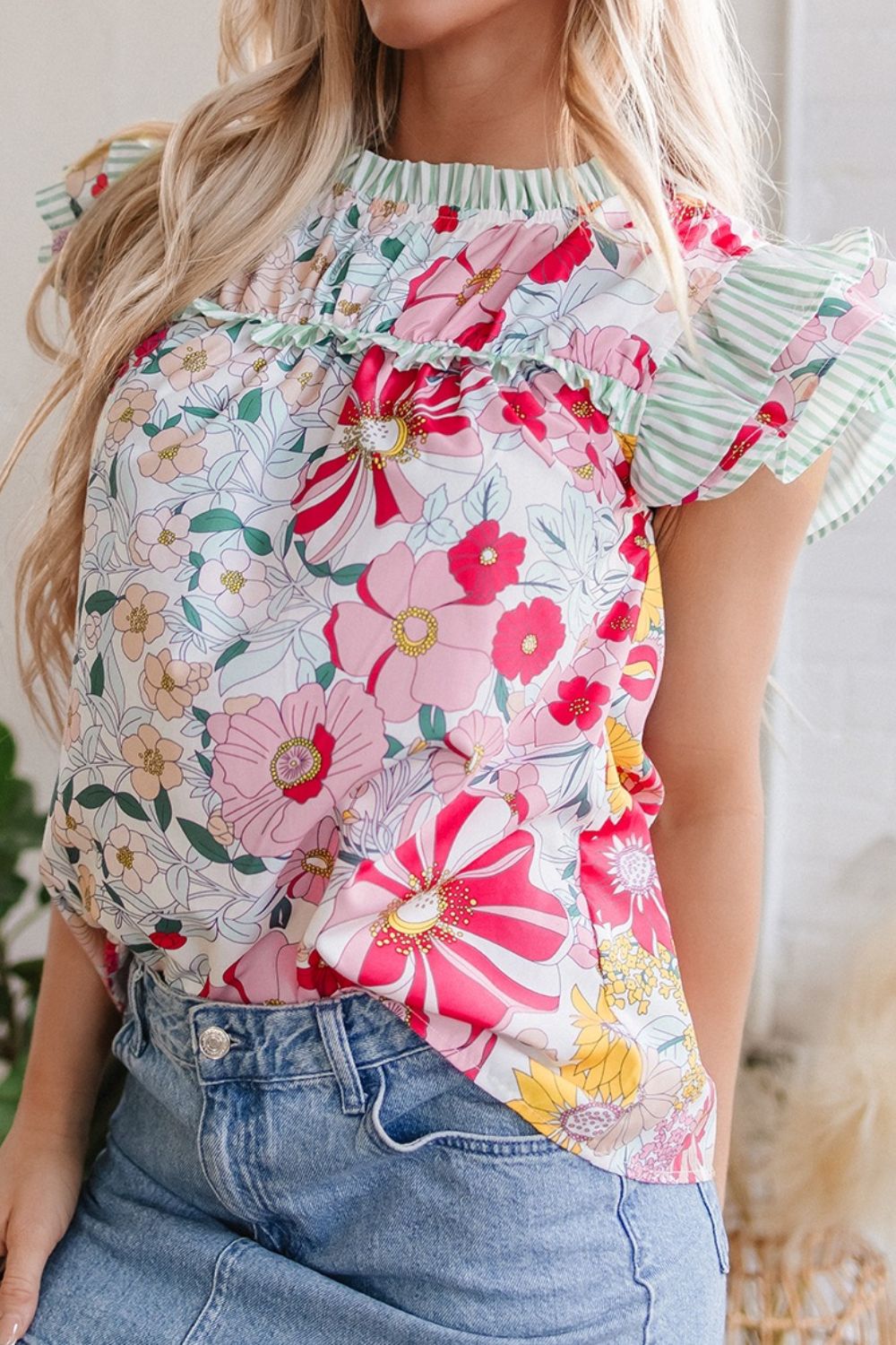 Floral ruffle sleeve blouse with smocked neckline and green stripe accents.