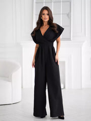Black wide-leg romper with surplice V-neckline and flutter sleeves.