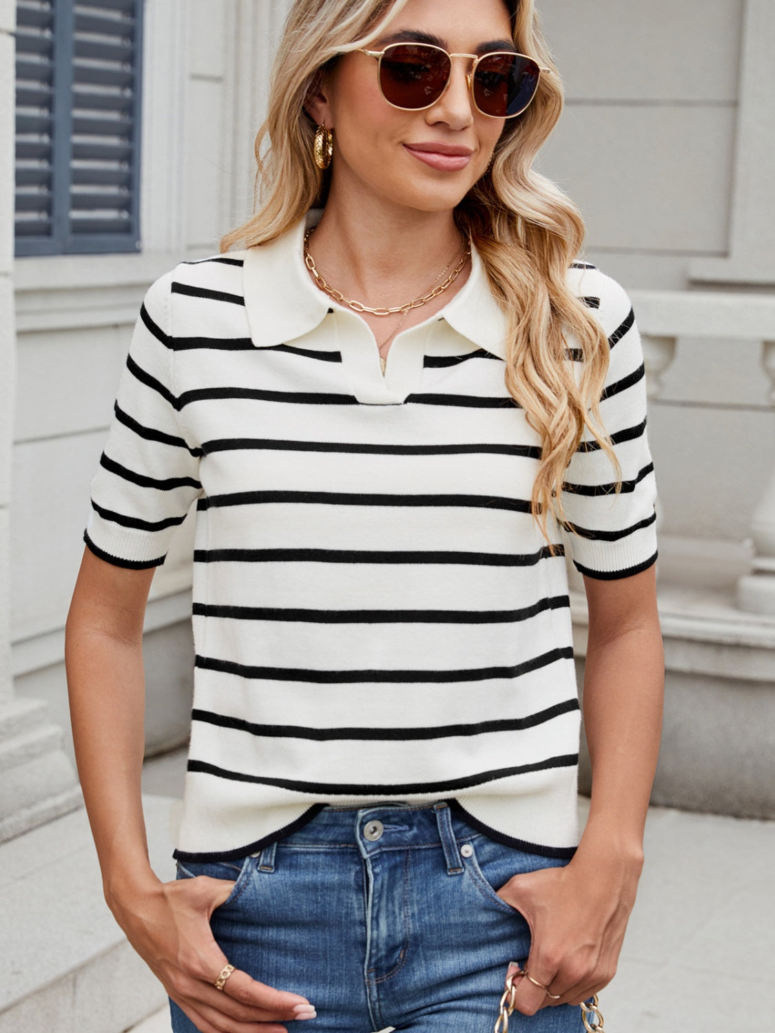 Nautical stripe knit polo top in black and white with short sleeves and a collar.