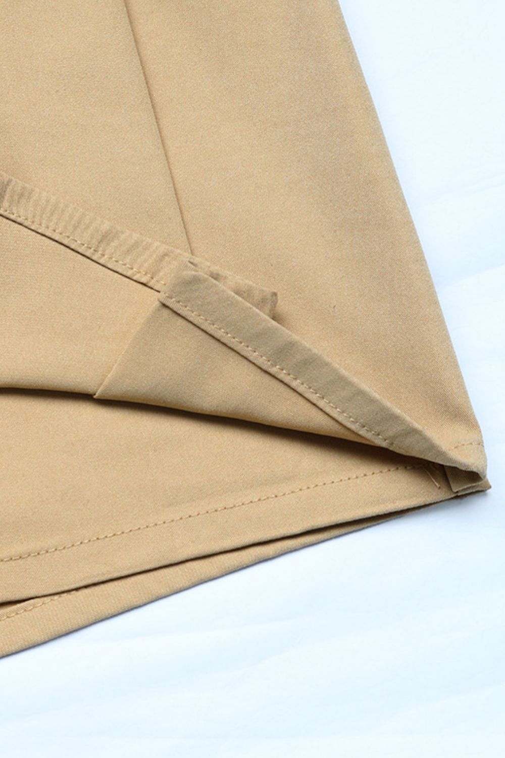 Tan skort shorts with visible pleats and stitching details.
