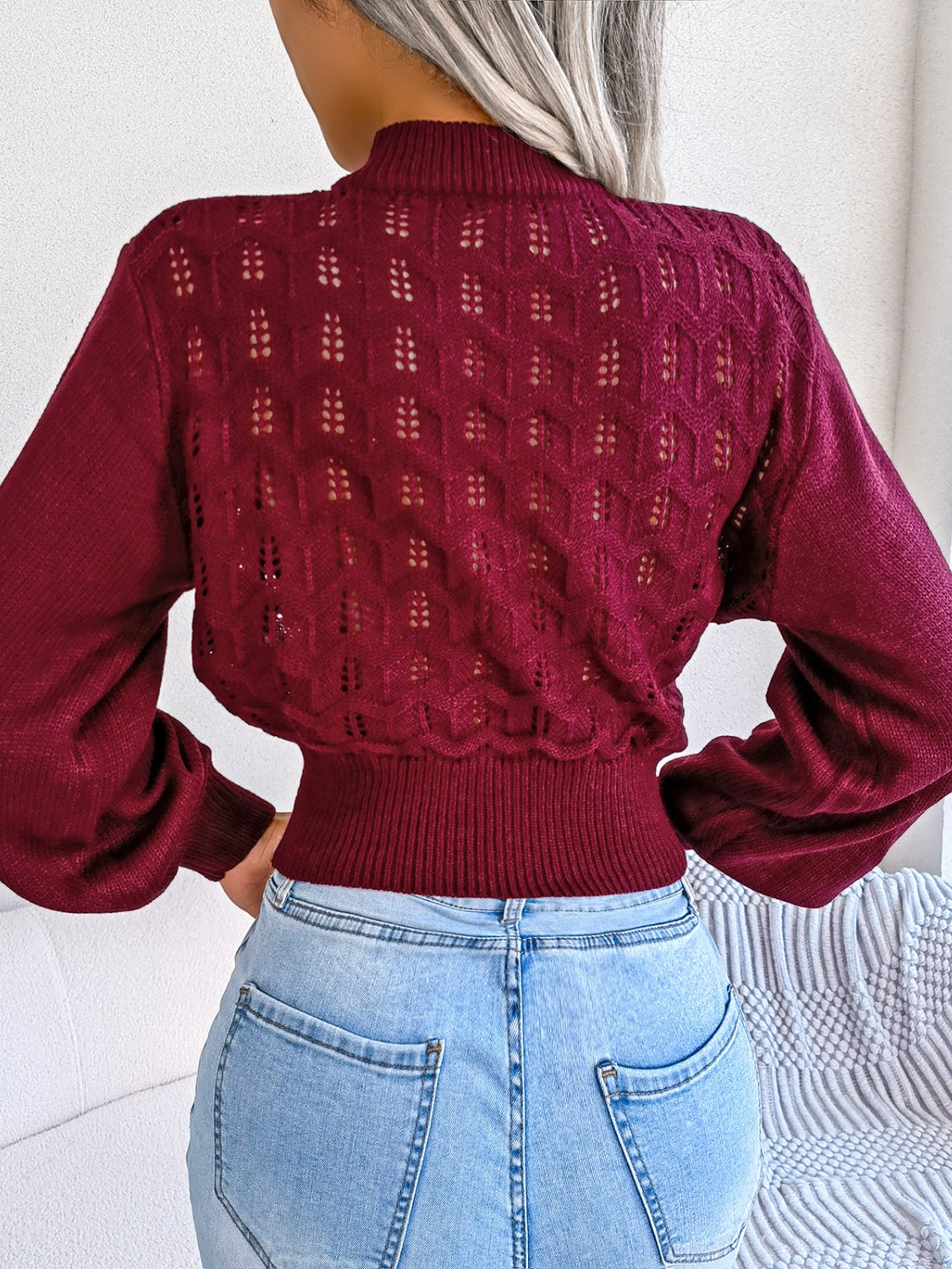Burgundy openwork knit sweater with puff sleeves and mock neck, cropped length.