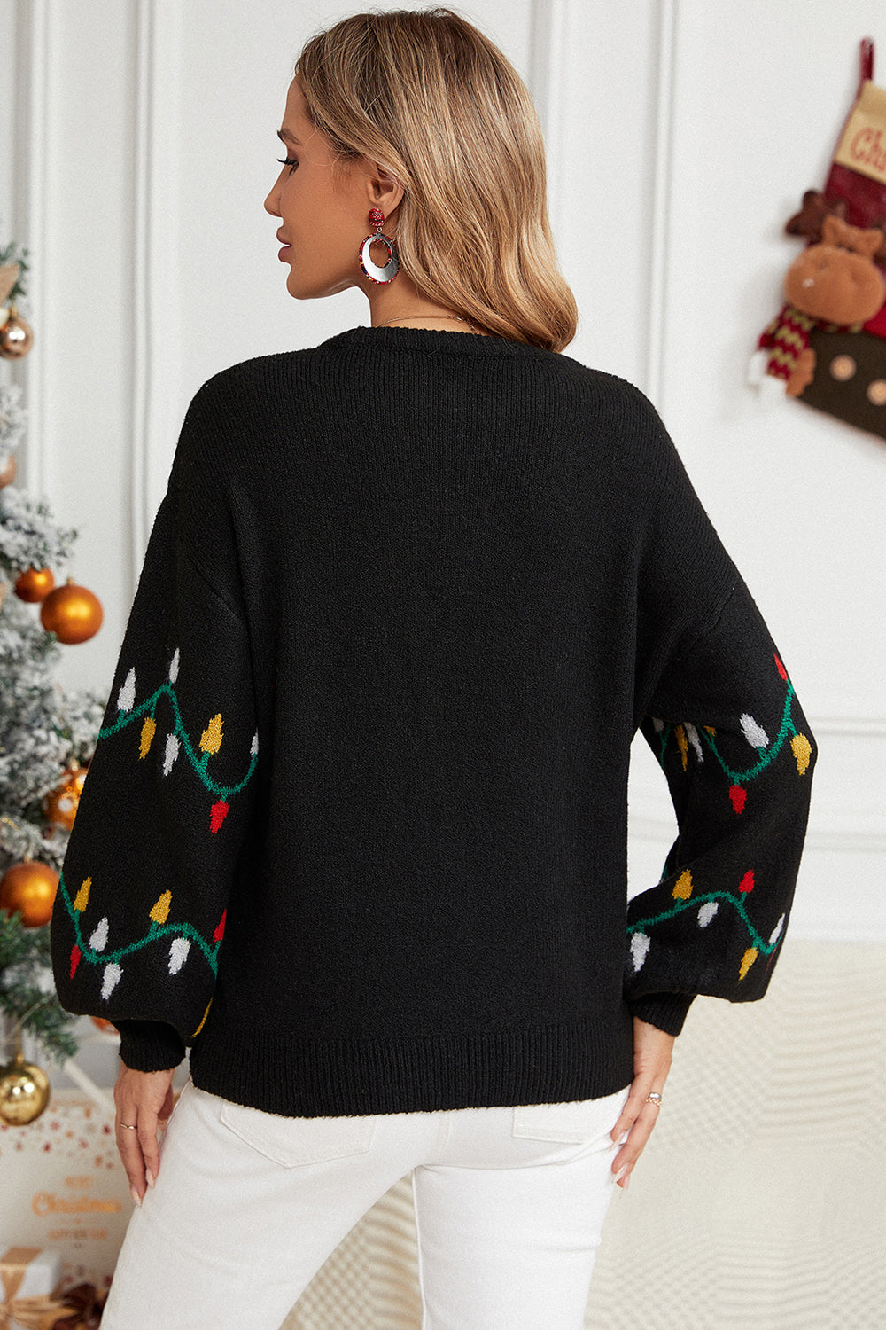 Black acrylic sweater with colorful Christmas lights pattern on sleeves.