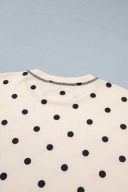 Cream polyester bikini top with navy polka dots and contrast stitching.