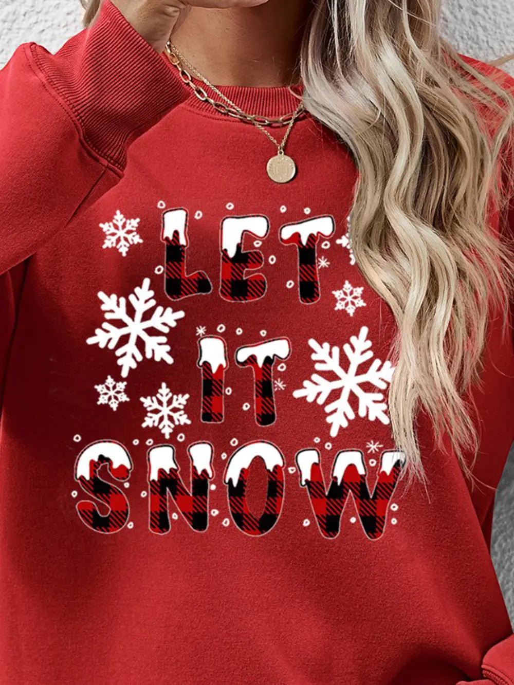 Red crewneck sweatshirt with "Let It Snow" graphic and buffalo plaid lettering.