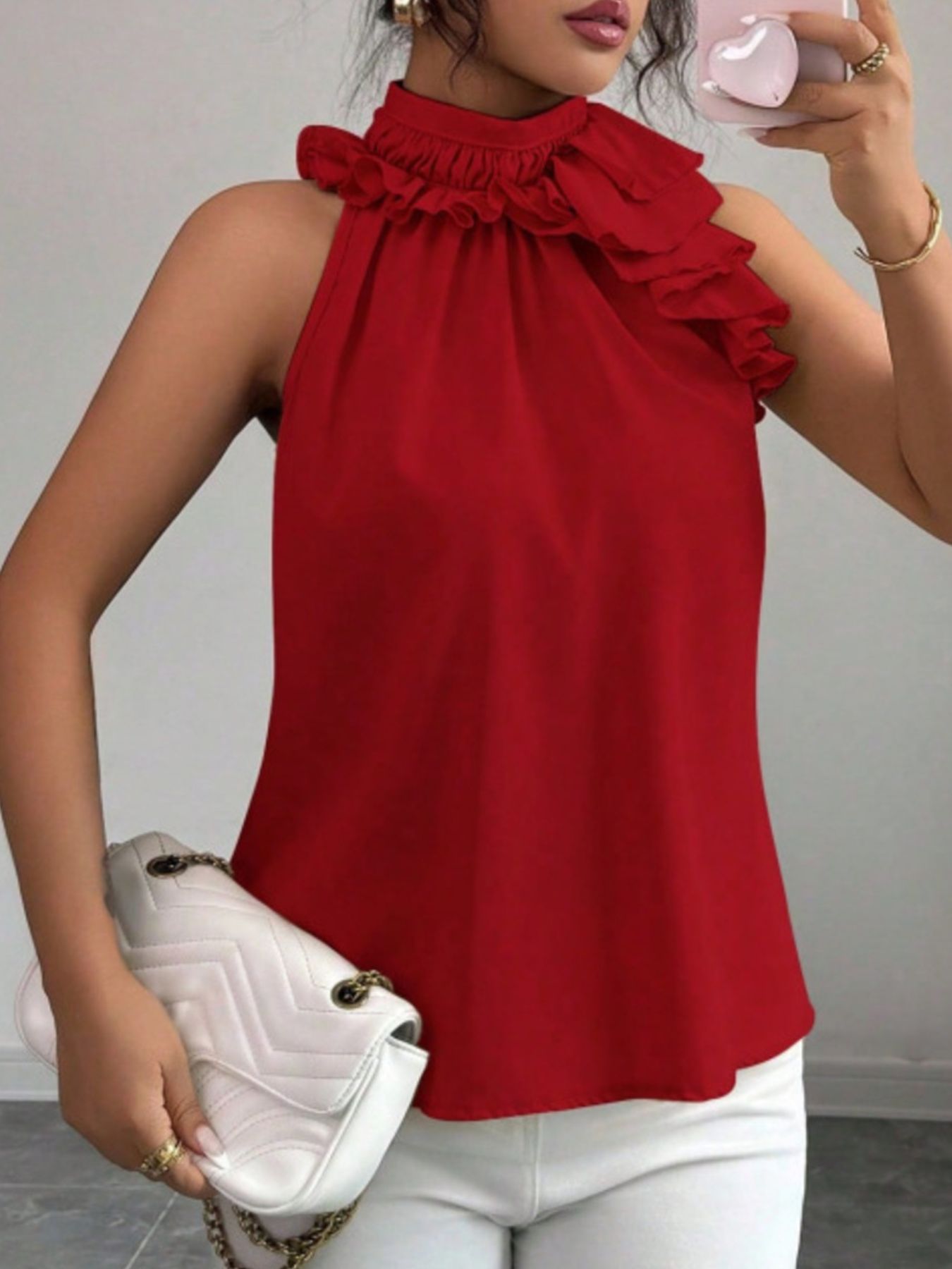 Red ruffled high neck sleeveless blouse with a casual cut.