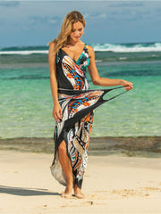 Multicolor graphic print pareo wrap with a deep V-neck and high slit, styled as a beach cover-up.