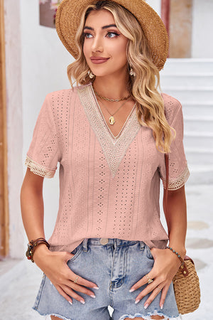 Blush pink eyelet v-neck blouse with lace trim on neckline and sleeves.