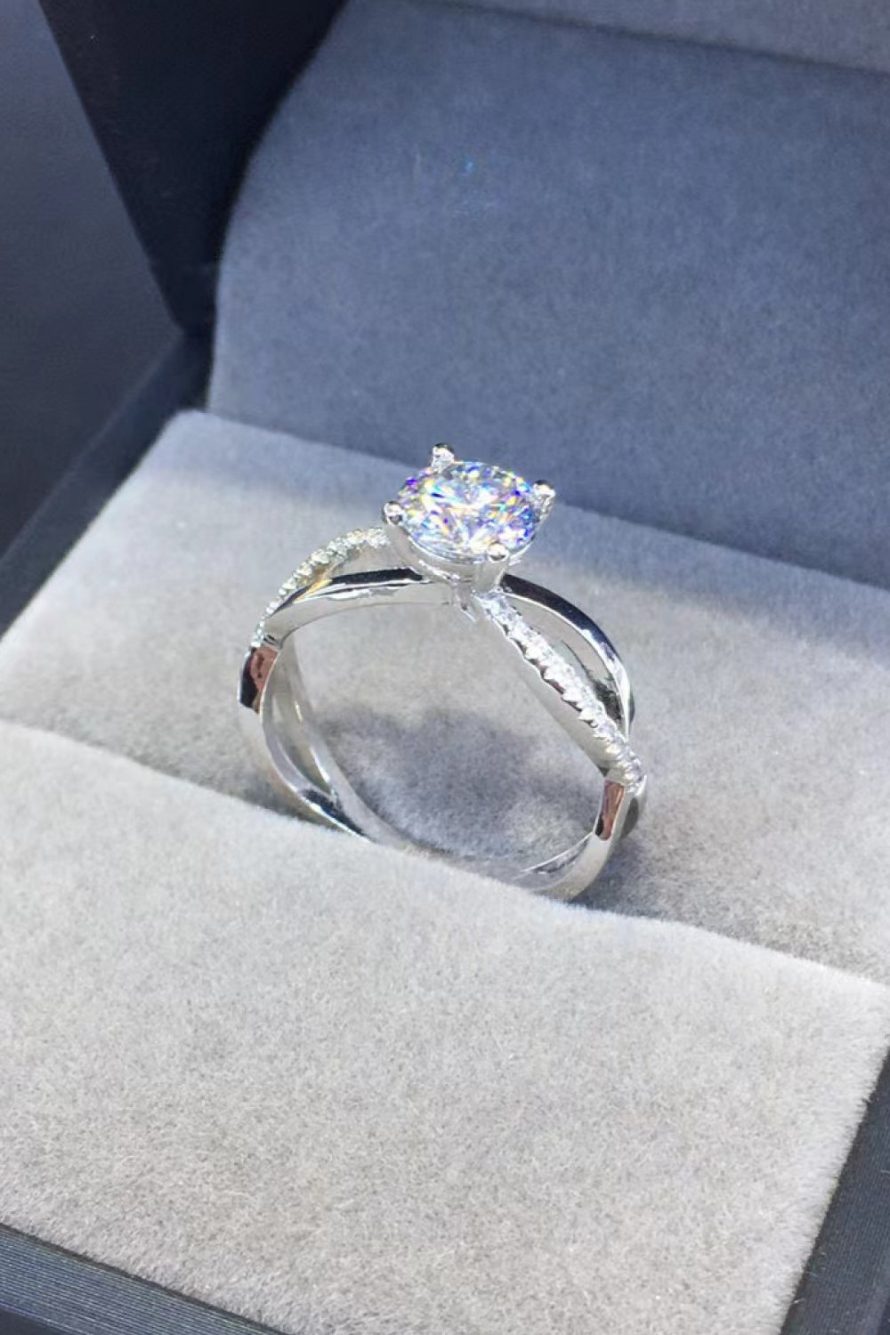 Silver crisscross ring with diamond halo and accent stones.