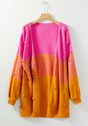 Textured colorblock bobble cardigan in pink and caramel acrylic with balloon sleeves.