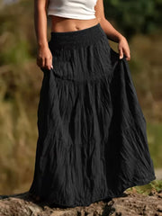 Black tiered maxi skirt with smocked waist and flowing bohemian style.