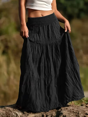 Black tiered maxi skirt with smocked waist and flowing bohemian style.