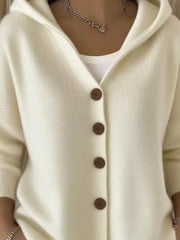 Cream hooded knit cardigan with button front and brown buttons, worn over a white tank.
