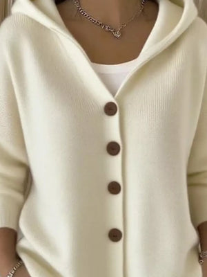 Cream hooded knit cardigan with button front and brown buttons, worn over a white tank.