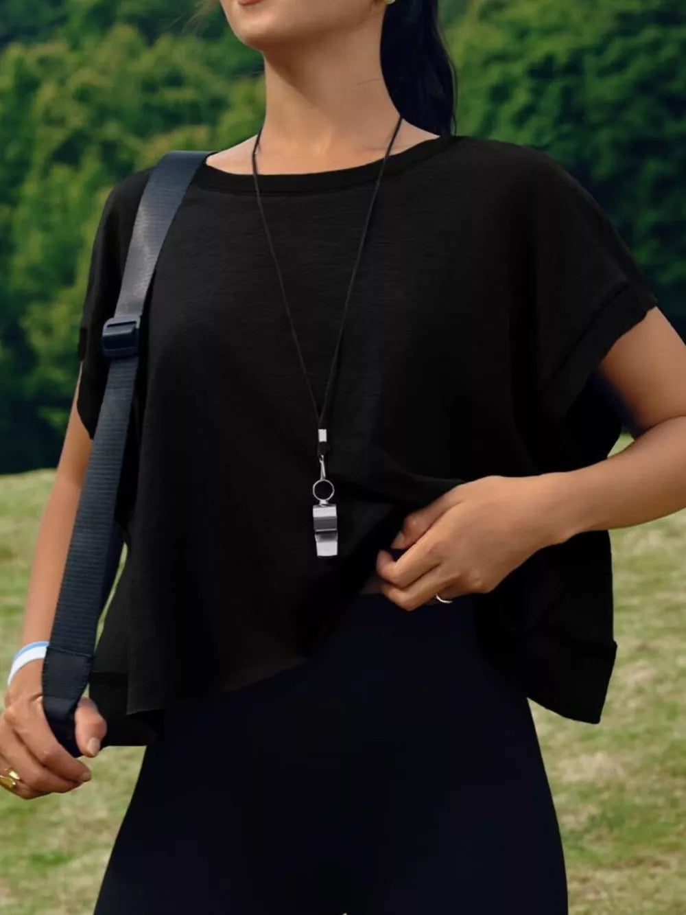 Black t-shirt with exposed seams and cutout back detail.