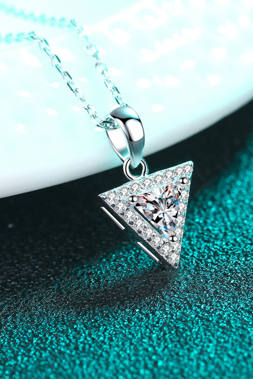 Silver geometric halo moissanite necklace with a triangle-cut center stone and pave accents.