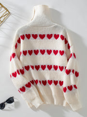 Cream turtleneck sweater with red heart intarsia pattern and ribbed knit details.