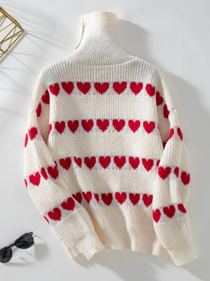 Cream turtleneck sweater with red heart intarsia pattern and ribbed knit details.