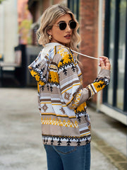 Aztec print zip-up hooded jacket with drawstring in tan, yellow, white, and black.