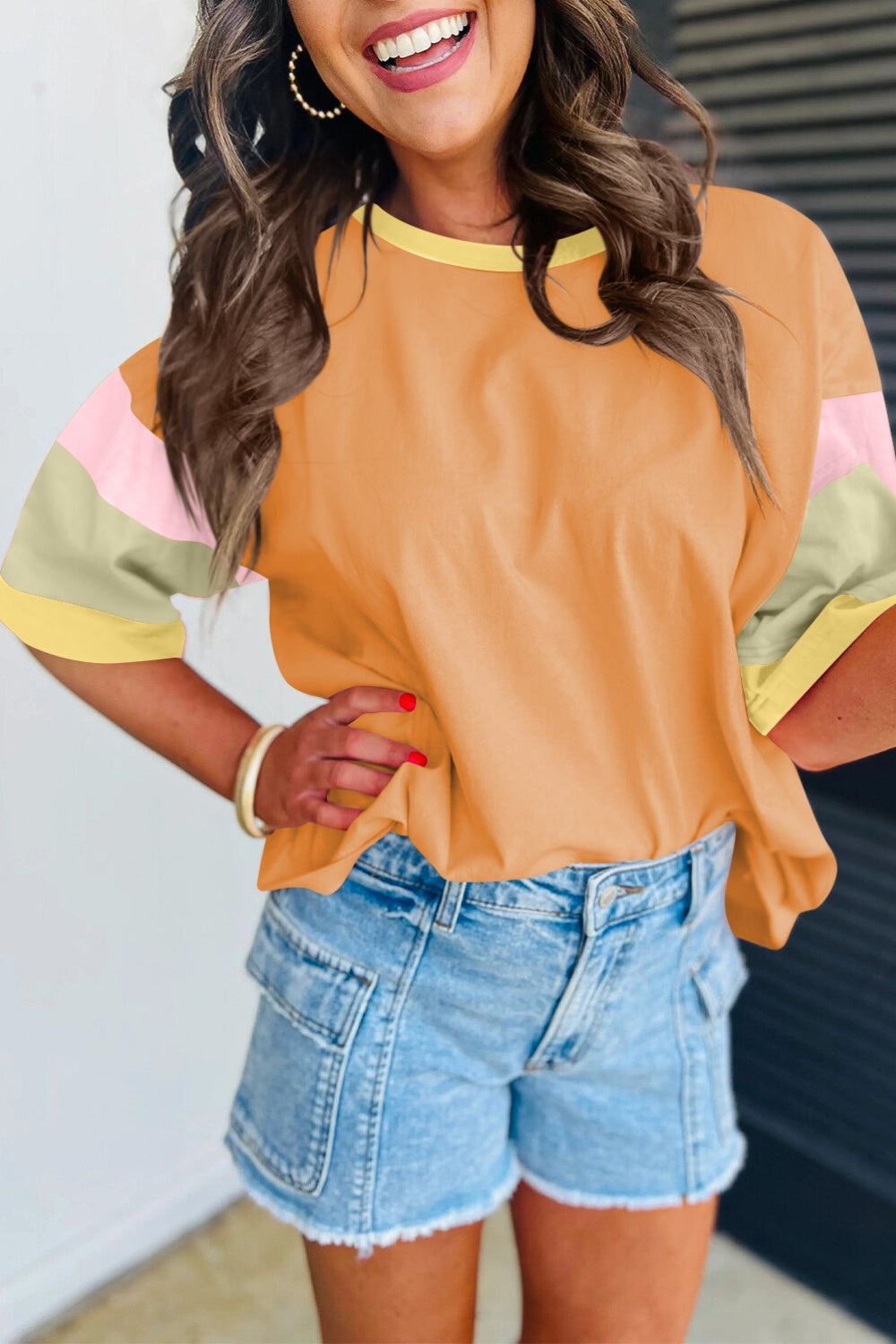 Panel sleeve crewneck tee in orange with colorblock sleeves and yellow neckline.