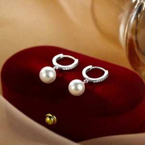 Elegant pearl drop hoop earrings with crystal accents.