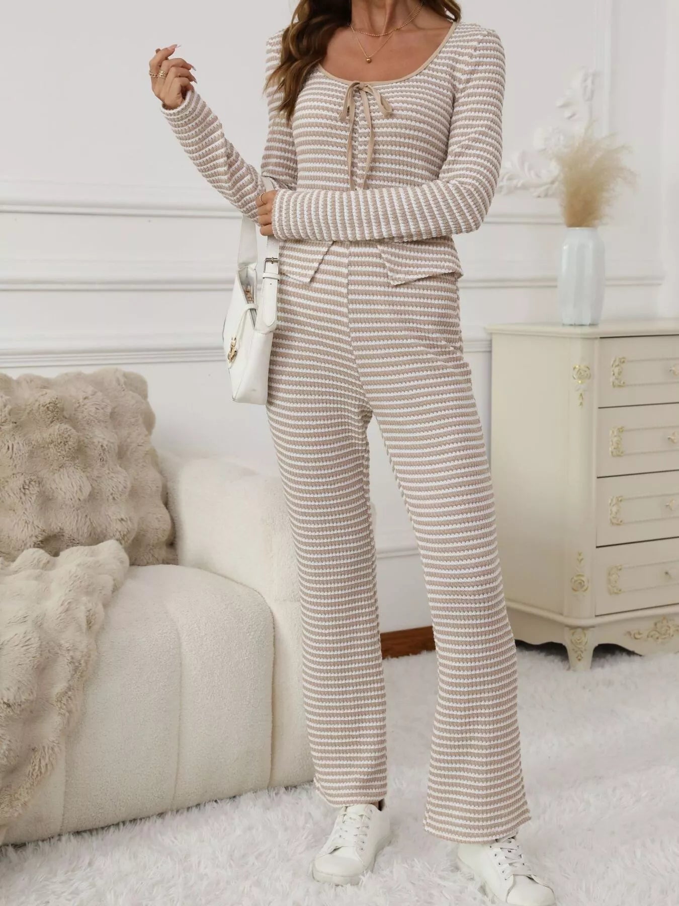 Tied two-piece set in apricot stripes with a tie-neck long sleeve top and flared pants.