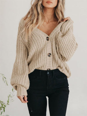 Camel knit cardigan with voluminous sleeves and button front, styled with black jeans.