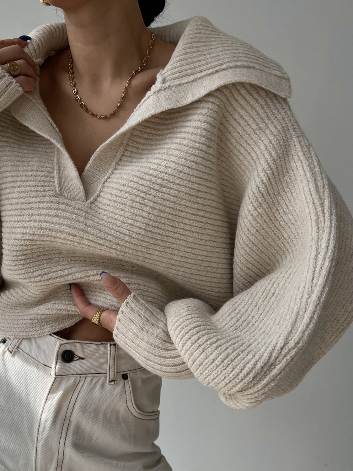 Wide collar balloon sleeve knit sweater in tan with ribbed texture and a deep V-neck.