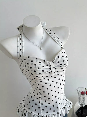 White polka dot halter cami with bow detail and ruffled hem.