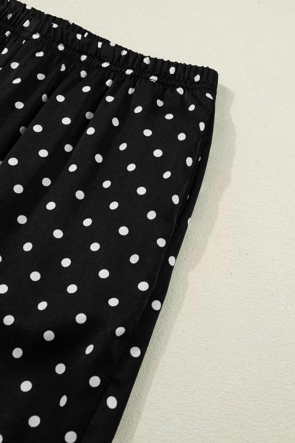 Black polka dot wide-leg maternity trousers with elastic waistband and side pockets.
