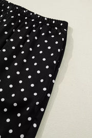 Black polka dot wide-leg maternity trousers with elastic waistband and side pockets.