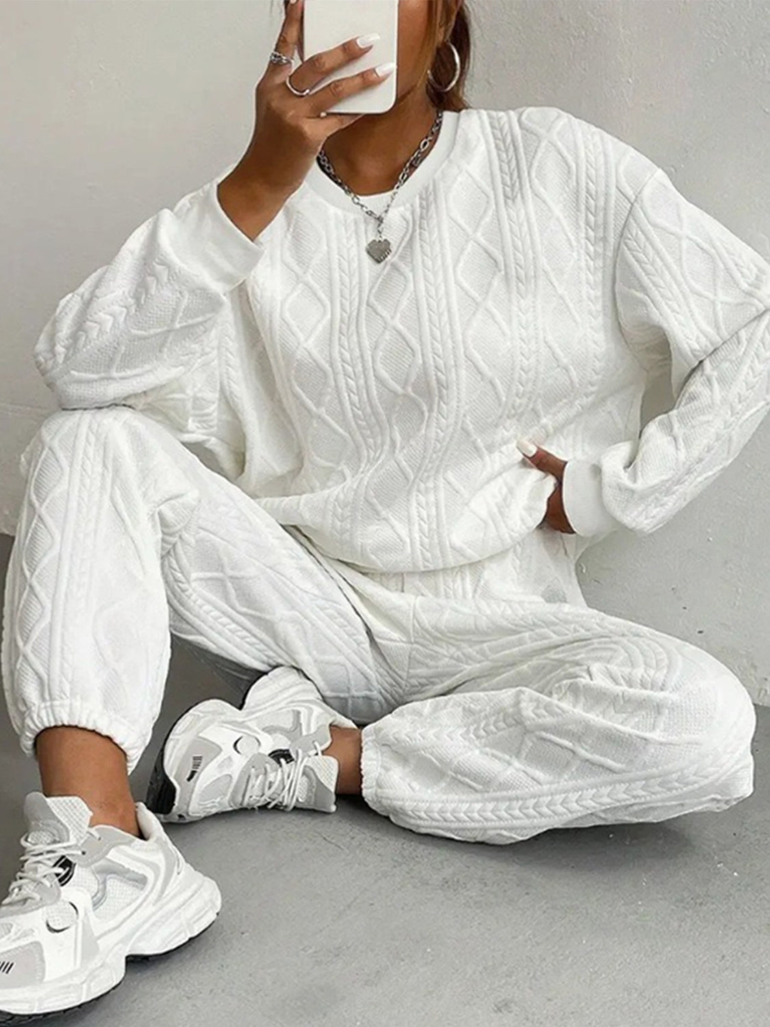 White cable knit loungewear set with crew neck sweatshirt and cuffed pants.