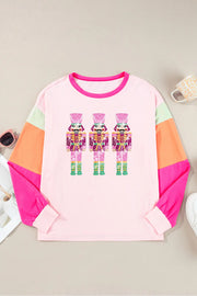 Blush pink long sleeve tee with colorblock sleeves and a graphic of three sequined nutcrackers.