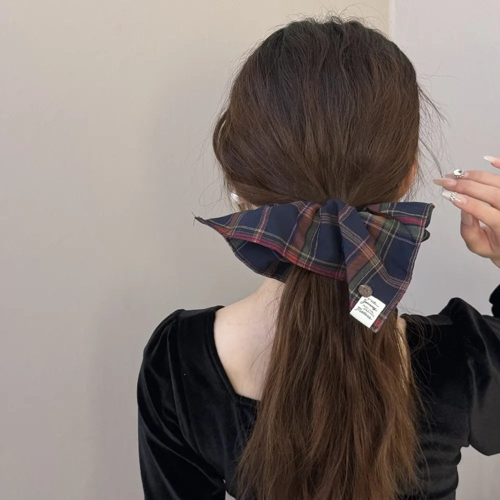 Plaid bow-tie scrunchie with button detail in Indigo, featuring a tartan pattern.