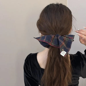 Plaid bow-tie scrunchie with button detail in Indigo, featuring a tartan pattern.