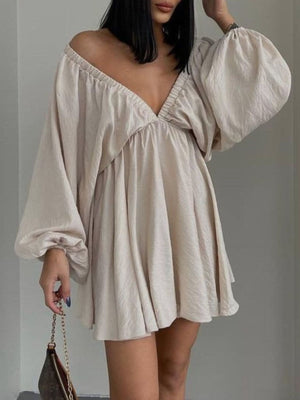 Beige ruched V-neck dress with balloon sleeves and a flowy skirt.