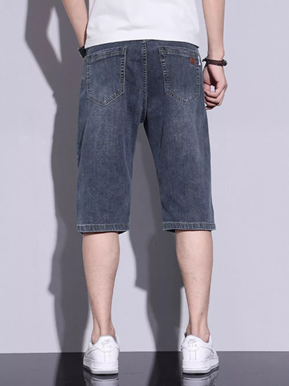 Men's classic washed denim shorts in dusty blue with button closure and back pockets.