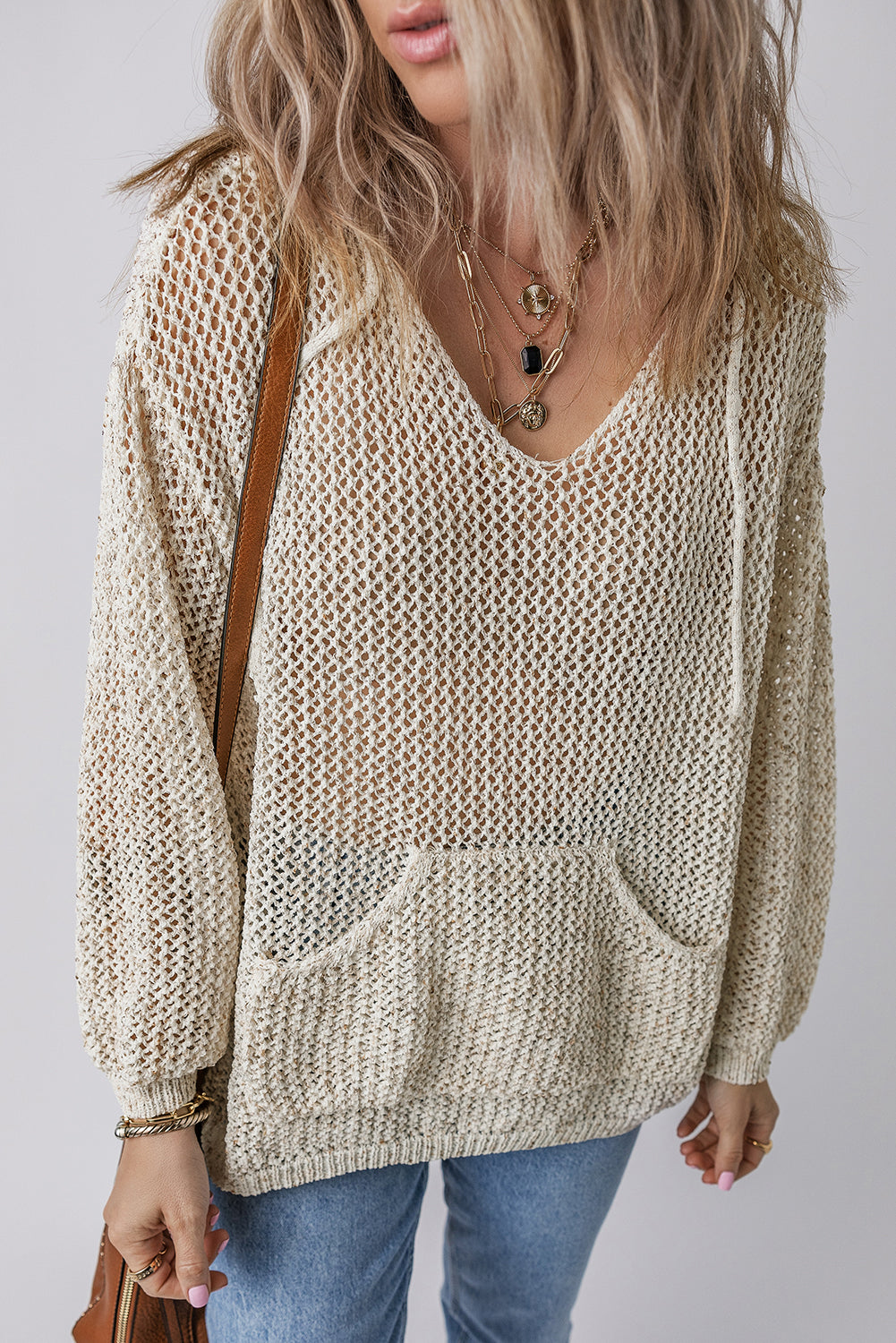 Beige open-knit V-neck hoodie pullover with front pocket and drawstring hood.