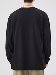 Oversized black cotton long-sleeve tee with crew neck, relaxed fit.