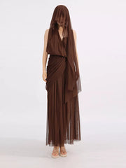 Draped one-shoulder maxi dress in coffee brown with sheer overlay and flowing skirt.