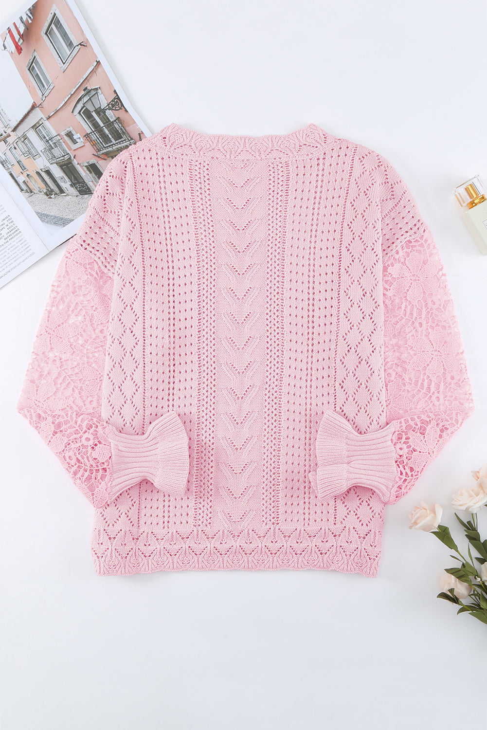 Blush pink openwork knit sweater with lace sleeves and ruffled cuffs.