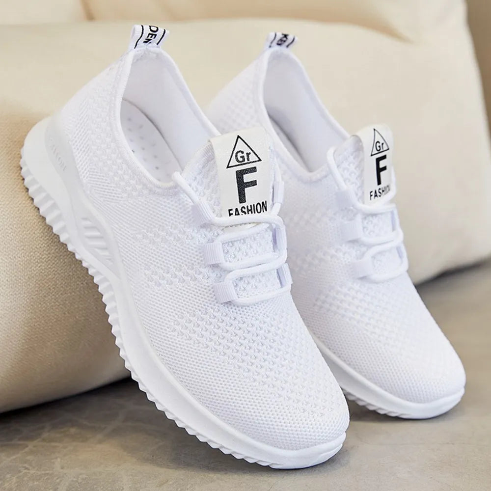 White breathable knit runner sneakers with logo detail and lace-up closure.