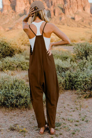 Brown cotton jumpsuit with wide legs and pockets, worn with a white tank top.