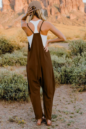 Brown cotton jumpsuit with wide legs and pockets, worn with a white tank top.