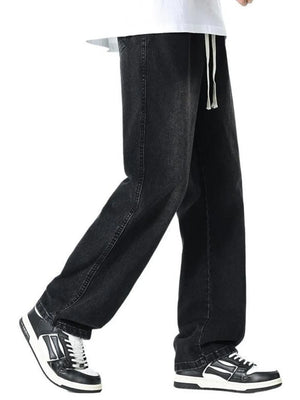 Relaxed wide leg black cotton jeans with drawstring waist and visible stitching detail.