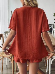 Terracotta linen lounge set with a tie-front top and shorts, featuring a relaxed fit and textured fabric.