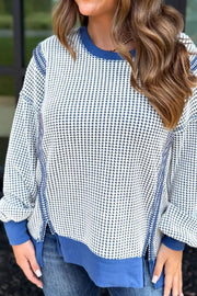 Light blue sweatshirt with contrast stitching, crew neck, and side slits.
