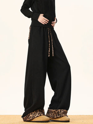 Black sweatpants with wide legs and leopard print trim on the cuffs and drawstring.